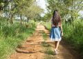 Woman Wearing Blue and White Skirt Walking Near Green Grass during Daytime