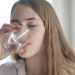 Woman in White Shirt Drinking Water From Clear Glass with Her Eyes Closed