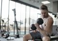 Man in White Tank Top and Grey Shorts Lifting Dumbbell