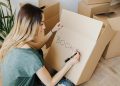 Content woman writing on cardboard container word book