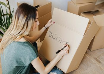 Content woman writing on cardboard container word book