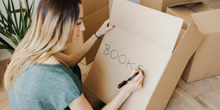 Content woman writing on cardboard container word book