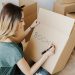 Content woman writing on cardboard container word book