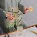 Person Holding White Flower in Clear Glass Vase