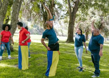 Group Of People In Blue Crew Neck Shirts Raising Their Hands