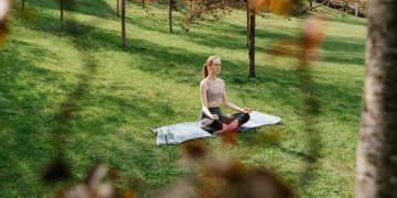 A Woman Meditating at a Park