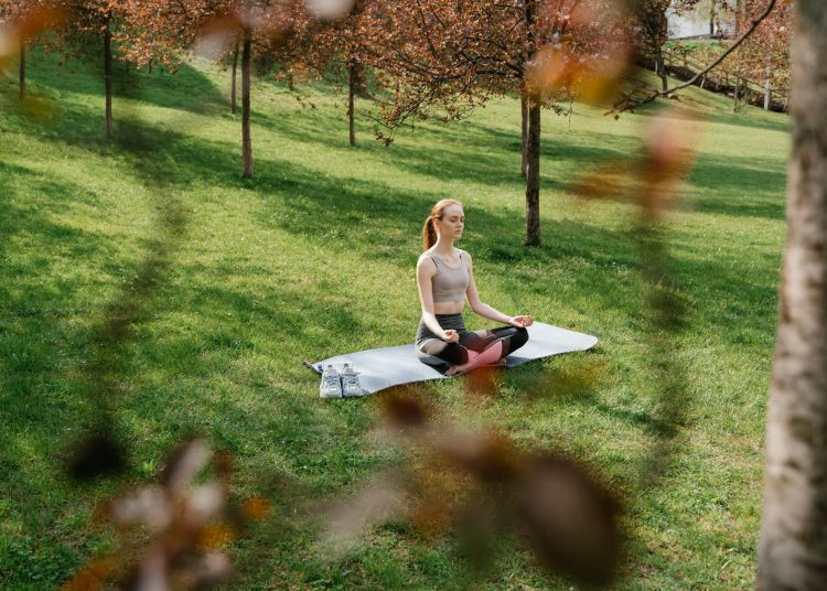 A Woman Meditating at a Park